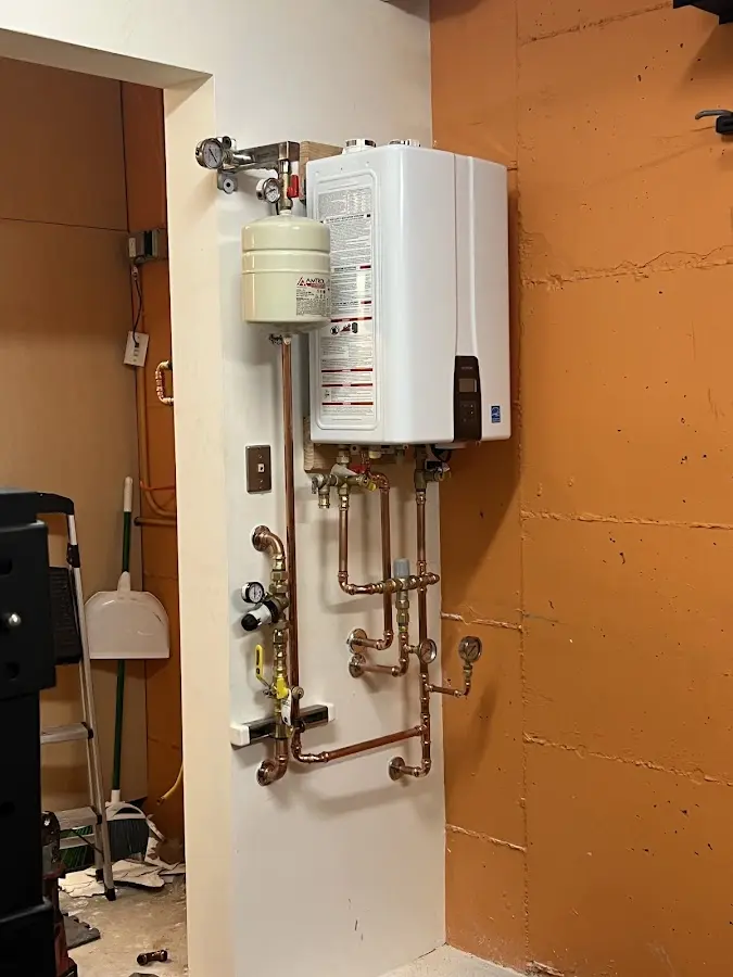 Plumbing technician inspecting water heater connections in Konterra